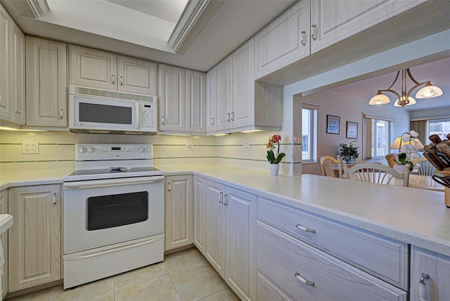 kitchen featuring white appliances, decorative light fixtures, light tile patterned floors, tasteful backsplash, and a notable chandelier