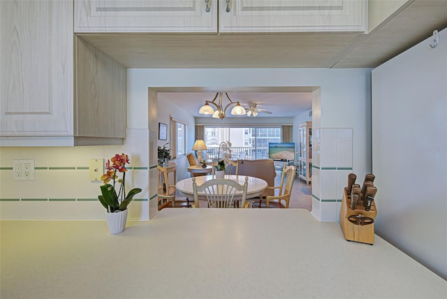 dining area featuring ceiling fan with notable chandelier