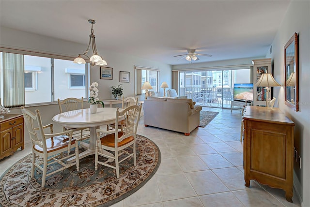 dining space featuring ceiling fan with notable chandelier and light tile patterned flooring