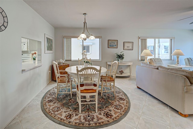 dining room with ceiling fan with notable chandelier and light tile patterned floors