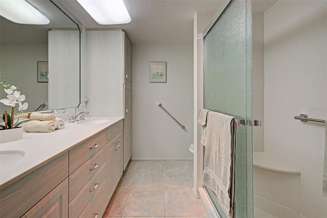 bathroom featuring tile patterned flooring, vanity, a shower with door, and toilet