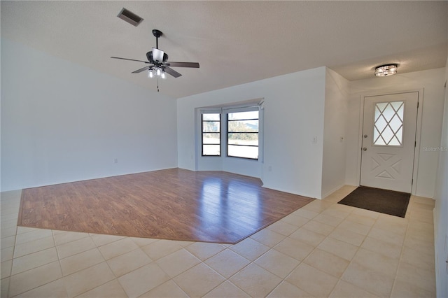 entryway featuring ceiling fan, light hardwood / wood-style flooring, and a textured ceiling