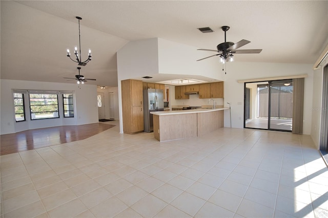 kitchen with stainless steel fridge with ice dispenser, kitchen peninsula, pendant lighting, light tile patterned flooring, and ceiling fan with notable chandelier