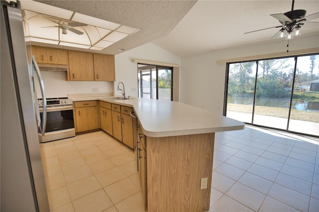 kitchen featuring light tile patterned floors, kitchen peninsula, a textured ceiling, and appliances with stainless steel finishes