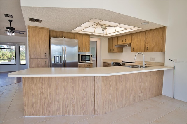 kitchen featuring kitchen peninsula, appliances with stainless steel finishes, a textured ceiling, and ceiling fan