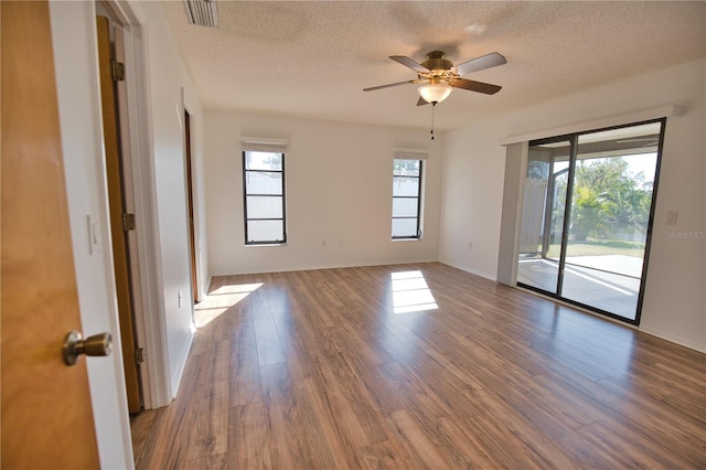 unfurnished room featuring dark hardwood / wood-style floors, ceiling fan, and a textured ceiling