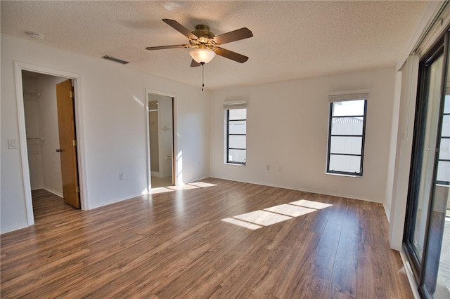 spare room with ceiling fan, dark wood-type flooring, and a textured ceiling