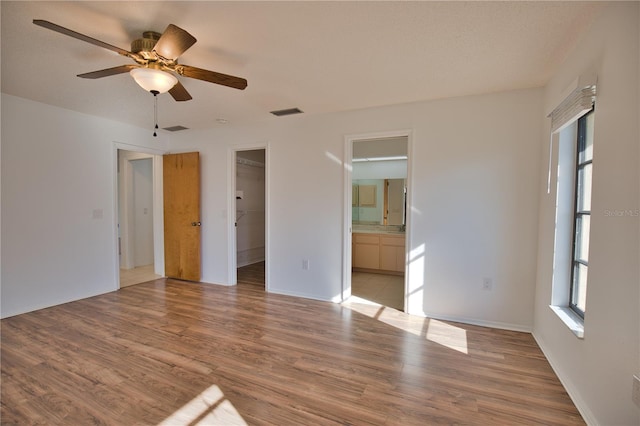 empty room with ceiling fan and light hardwood / wood-style flooring