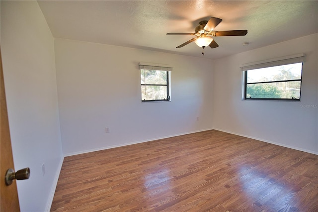 unfurnished room with hardwood / wood-style floors, ceiling fan, and a textured ceiling