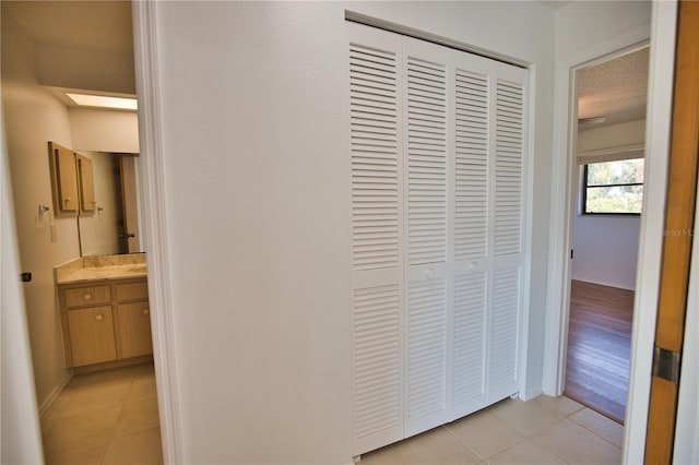 hall featuring light wood-type flooring and a textured ceiling