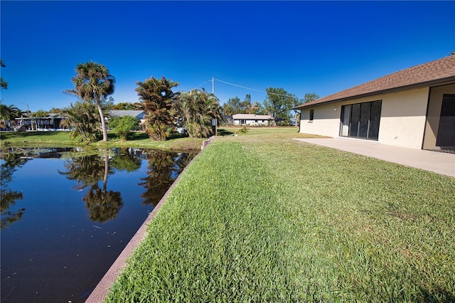 view of yard featuring a water view and a patio