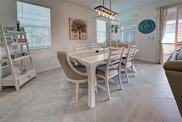 dining area with light tile patterned floors and a chandelier