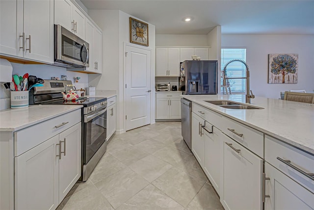 kitchen featuring light stone countertops, sink, white cabinets, and appliances with stainless steel finishes