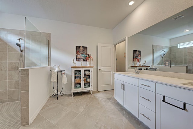 bathroom featuring tiled shower, vanity, and tile patterned floors