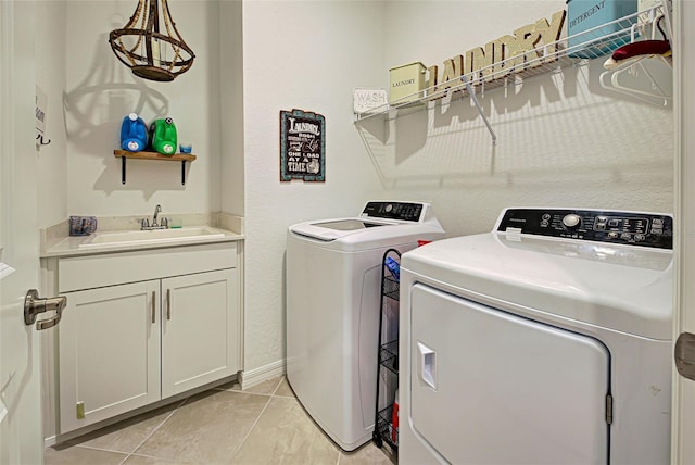 laundry room with cabinets, independent washer and dryer, sink, and light tile patterned floors