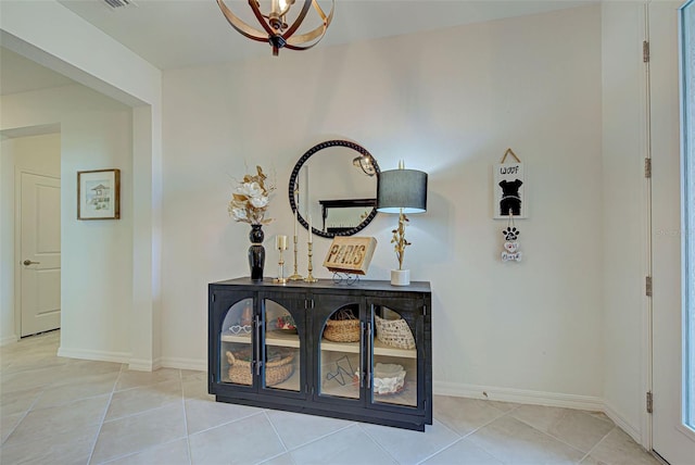 hall featuring light tile patterned floors and an inviting chandelier