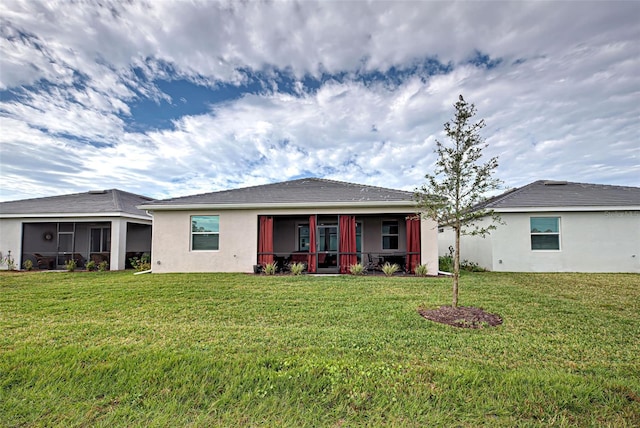 rear view of property featuring a sunroom and a yard