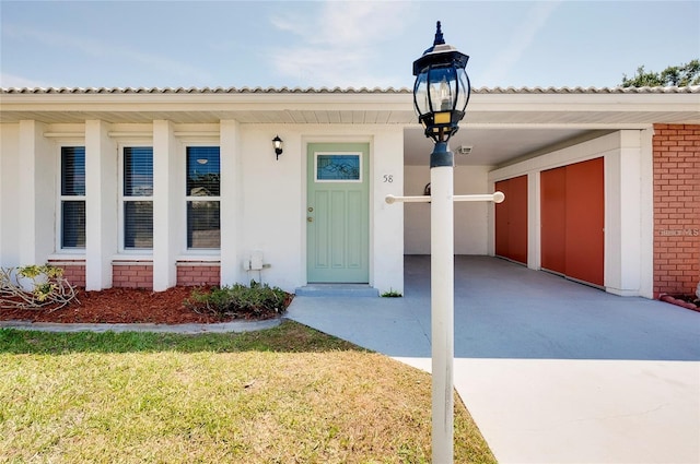 property entrance featuring a yard and a carport