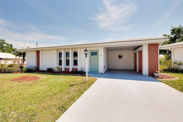 ranch-style home featuring a front lawn and a carport