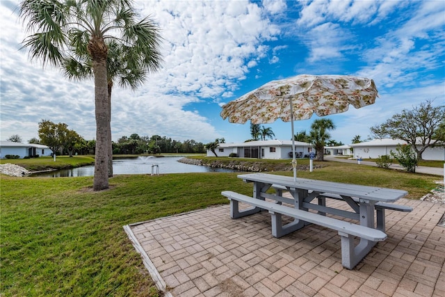 exterior space with a patio area, a yard, and a water view