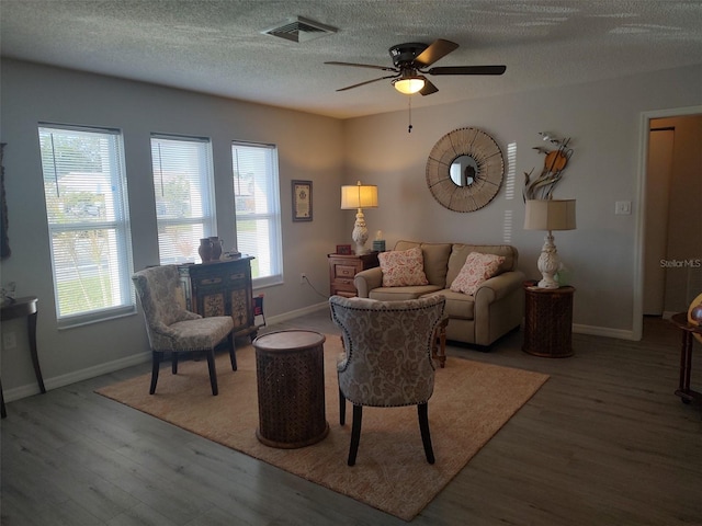 living room featuring a textured ceiling, hardwood / wood-style flooring, and ceiling fan