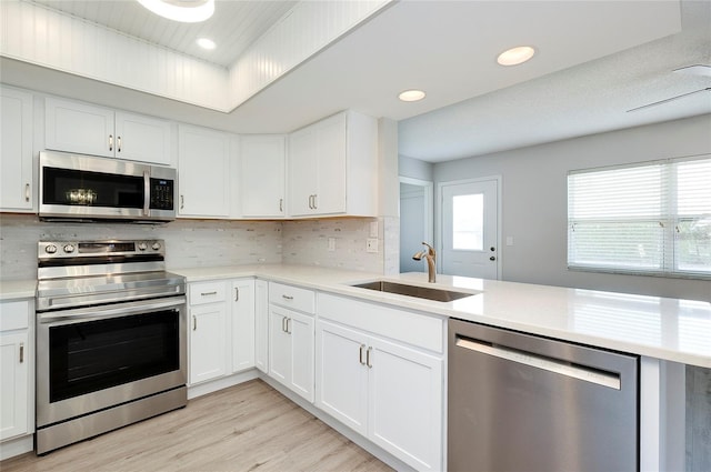 kitchen featuring appliances with stainless steel finishes, light hardwood / wood-style floors, and white cabinetry