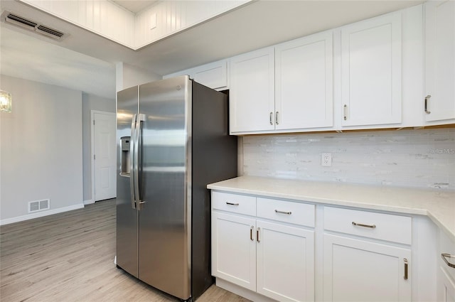 kitchen with light hardwood / wood-style floors, decorative backsplash, white cabinetry, and stainless steel fridge with ice dispenser