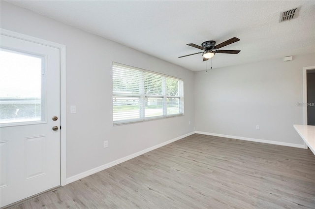 entryway featuring ceiling fan, light hardwood / wood-style floors, and a textured ceiling