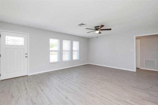 unfurnished living room with a textured ceiling, light hardwood / wood-style floors, and ceiling fan