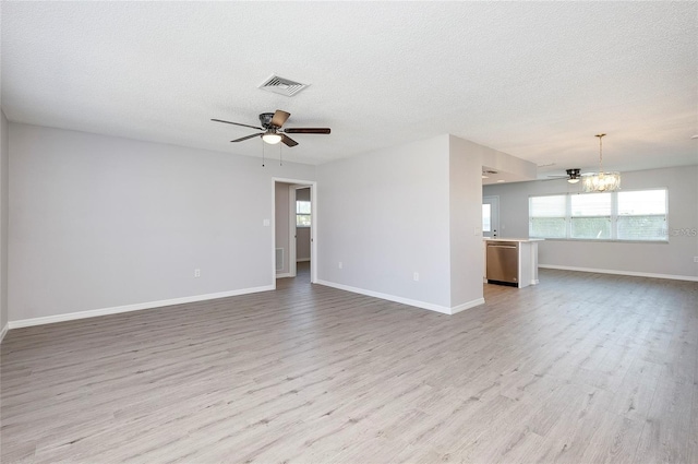 spare room featuring ceiling fan with notable chandelier, a textured ceiling, and light wood-type flooring