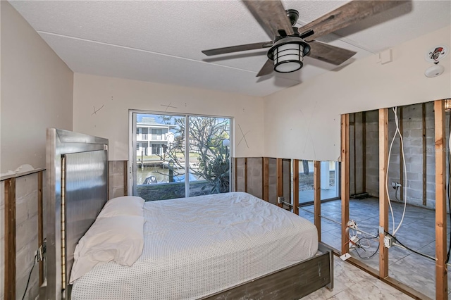 bedroom featuring a textured ceiling, access to outside, and ceiling fan