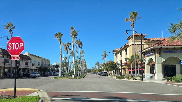 view of street with sidewalks, street lighting, traffic signs, and curbs