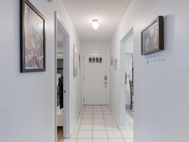 hall with light tile patterned floors and a textured ceiling