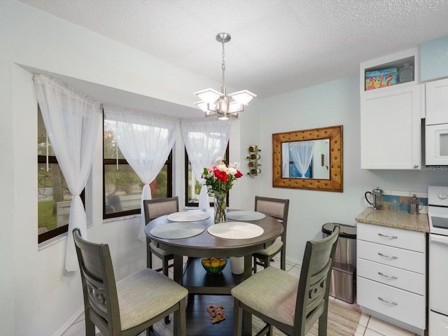 dining room with light tile patterned flooring, a textured ceiling, and a chandelier