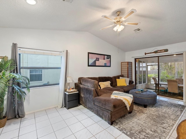 tiled living room with ceiling fan, lofted ceiling, and a textured ceiling