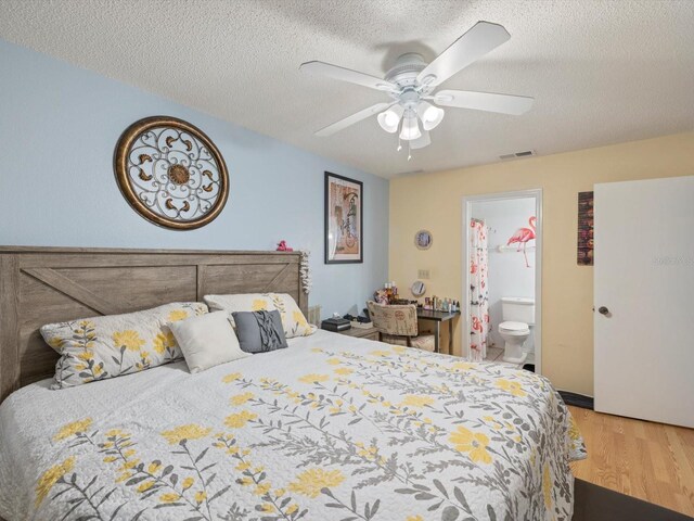 bedroom with hardwood / wood-style flooring, ceiling fan, a textured ceiling, and ensuite bath