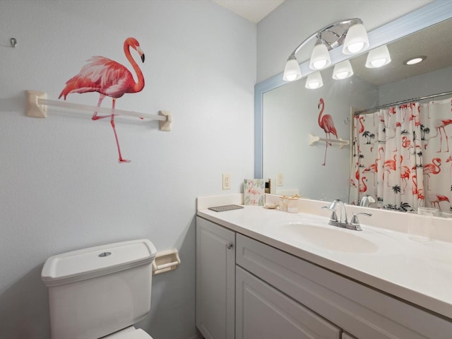 bathroom featuring walk in shower, vanity, and toilet