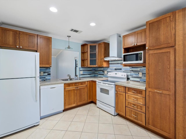 kitchen with sink, hanging light fixtures, wall chimney range hood, tasteful backsplash, and white appliances