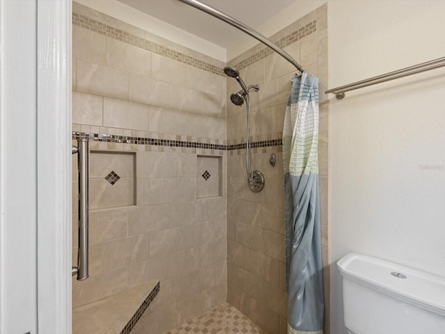 bathroom featuring a shower with curtain and toilet