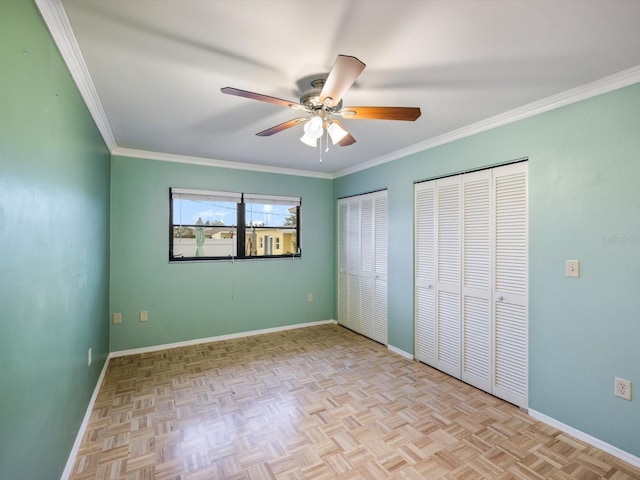 unfurnished bedroom with light parquet flooring, two closets, ceiling fan, and ornamental molding