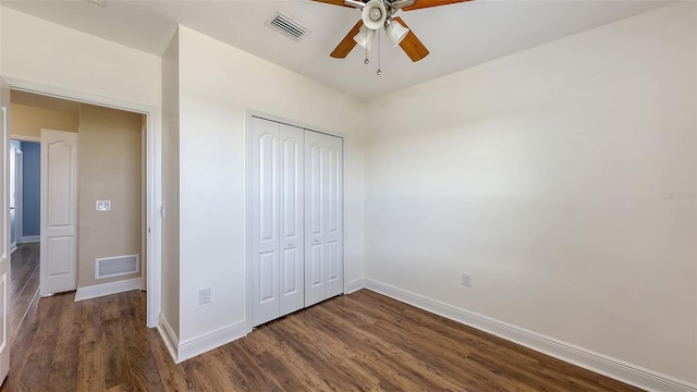 unfurnished bedroom with dark hardwood / wood-style floors, ceiling fan, and a closet