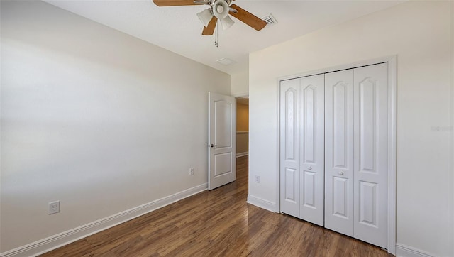 unfurnished bedroom with ceiling fan, dark wood-type flooring, and a closet