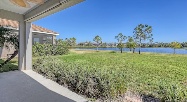 view of yard with a water view and ceiling fan