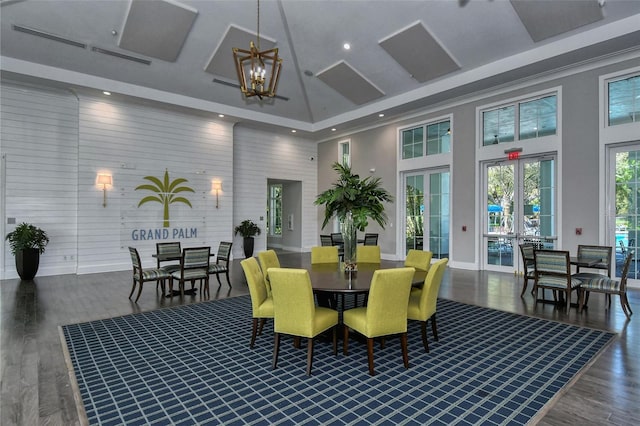 dining room featuring a high ceiling, dark hardwood / wood-style floors, an inviting chandelier, and french doors