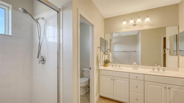 bathroom featuring tiled shower, vanity, and toilet