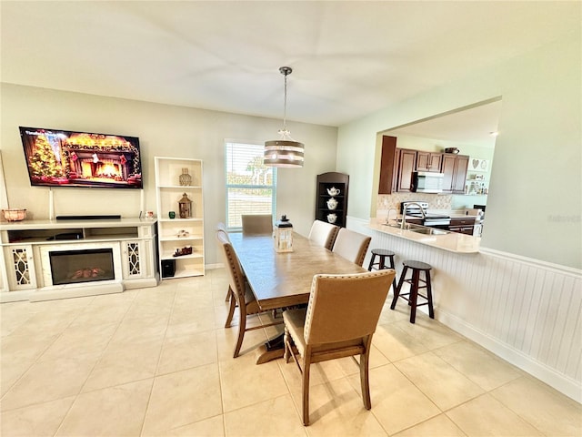 dining room with a notable chandelier, light tile patterned flooring, and sink