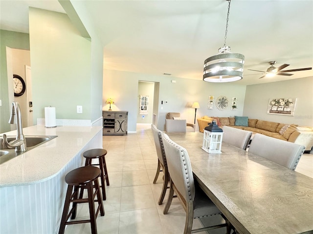 dining room with light tile patterned floors, ceiling fan, and sink