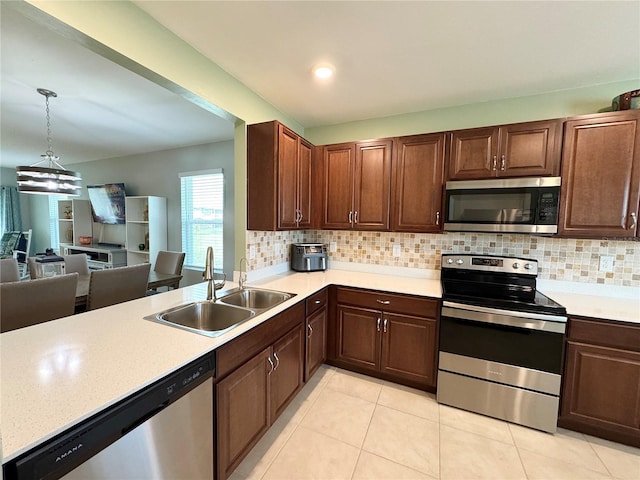 kitchen with backsplash, stainless steel appliances, sink, hanging light fixtures, and light tile patterned flooring