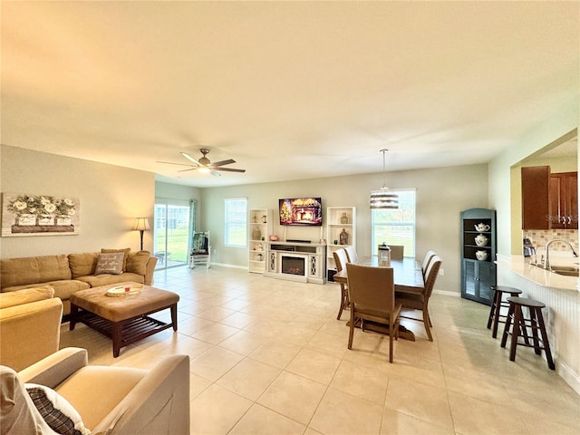 tiled living room with ceiling fan and sink