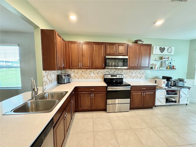 kitchen with light tile patterned floors, backsplash, stainless steel appliances, and sink